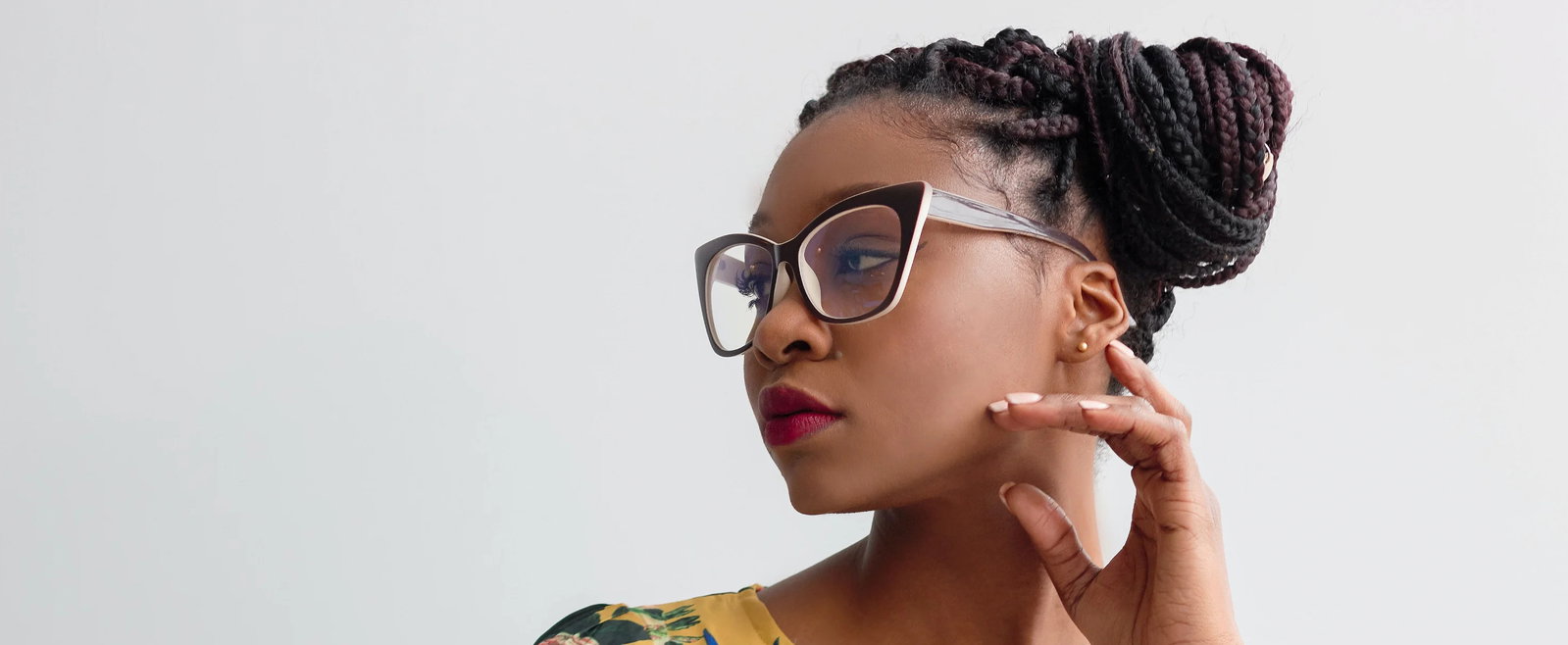 Das Bild zeigt das Gesicht einer jungen Frau mit Brille und Dreadlocks.